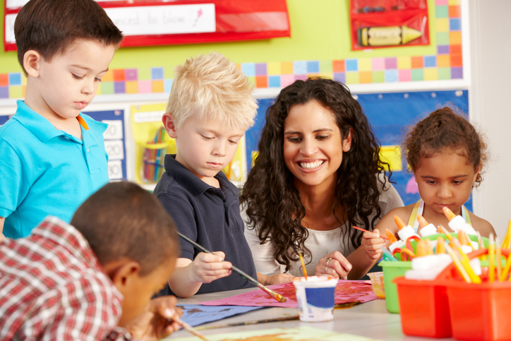 Diverse Group Of Elementary Age Schoolchildren In Art Class With Teacher