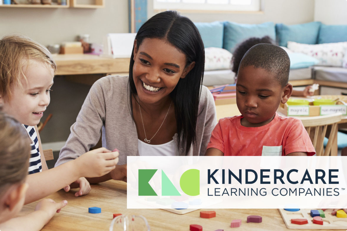 Teacher at table smiling with students and playing with a puzzle